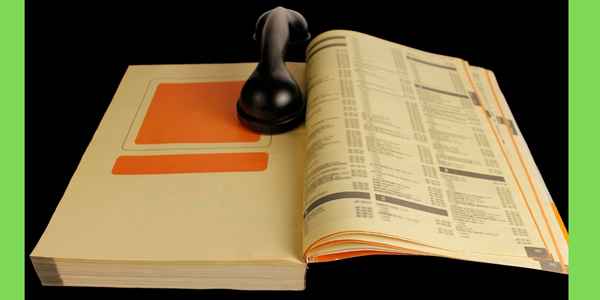 open telephone directory with a handset keeping the pages open